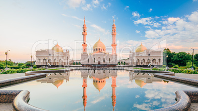 Beautiful White Mosque with Reflection  on Water at Sunset Light