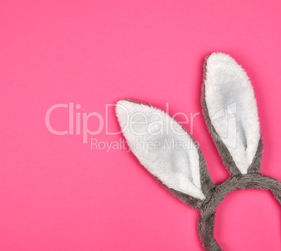Fur headdress of a hare with ears on a pink background