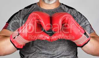 athlete in red boxing leather gloves shows hands with a heart sy