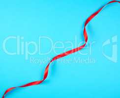twisted red silk ribbon, blue background