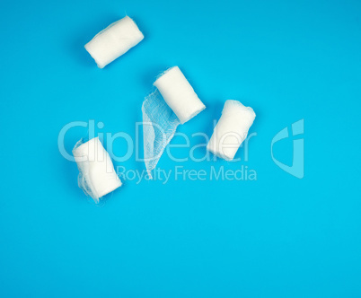 rolled up white sterile medical bandages on a blue background