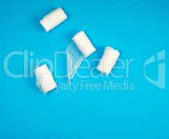 rolled up white sterile medical bandages on a blue background