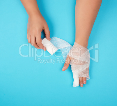 arm wrapped in a white sterile bandage on a blue background