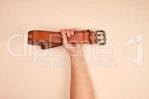 leather brown belt in a female hand