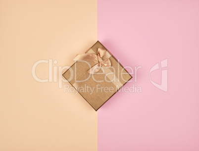 closed square box with a bow on an abstract colored background