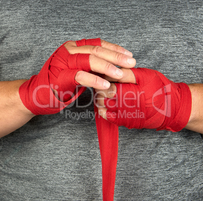 sportsman?s hands wrapped in a red elastic sports bandage