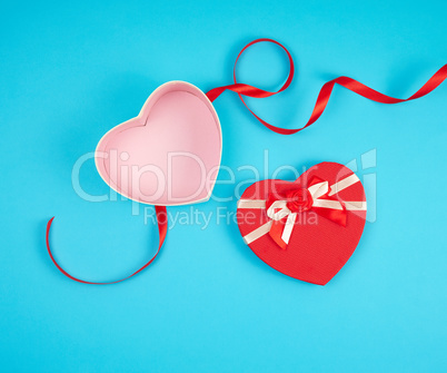 open red heart-shaped gift box with a bow on a blue background