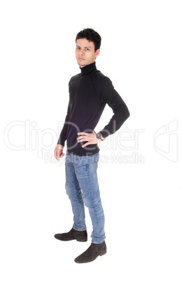 Handsome tall young man standing in jeans in the studio
