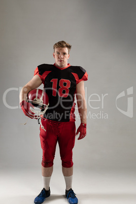 American football player standing with helmet