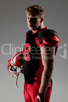 American football player standing with helmet