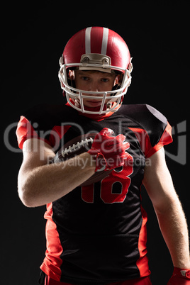 American football player in helmet holding rugby ball