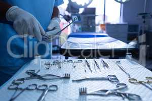 Surgeon holding surgical instrument in operating room of hospital