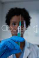 Female doctor holding syringe with needle at the hospital