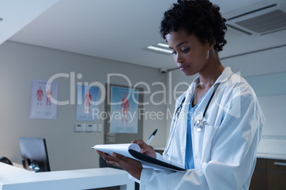 Female doctor writing on clipboard in the hospital