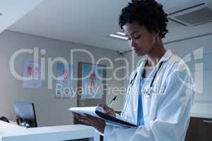 Female doctor writing on clipboard in the hospital