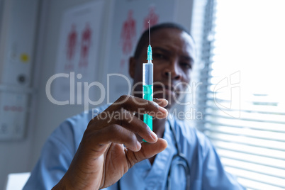 Male surgeon holding syringe with injection in the hospital
