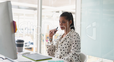 Female graphic designer using graphic tablet at desk