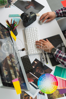 Male graphic designer working on computer at desk in office
