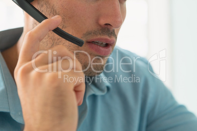 Male customer service executive talking on headset in office