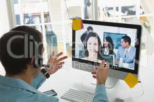 Male customer service executive making video call on computer at desk