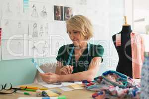 Female fashion designer checking color shade on a table