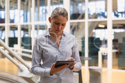 Businesswoman using digital tablet in the corridor at office