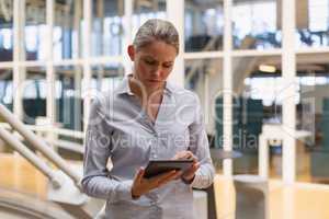 Businesswoman using digital tablet in the corridor at office