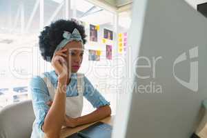 Tensed female graphic designer sitting at desk