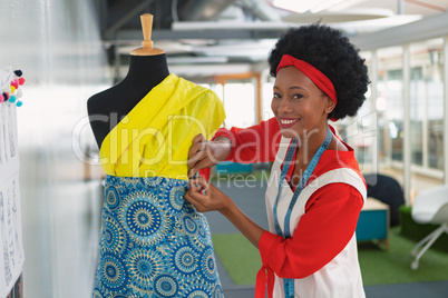 Female fashion designer dressing a mannequin in design studio