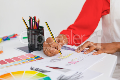Female fashion designer drawing a sketch at desk in design studio