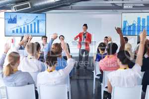 Business people raising their hands in a business conference