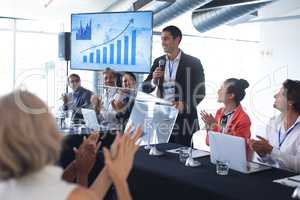 Audience applauding while speaker speaks in a business seminar