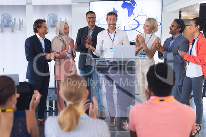 Businessman standing with colleagues and speaks in a business seminar
