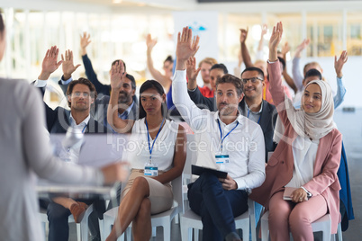 Audience raising their hands in a business conference