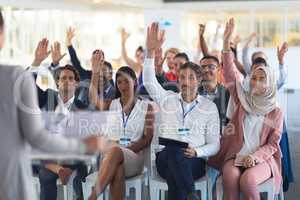 Audience raising their hands in a business conference