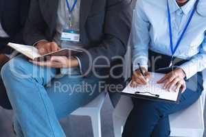 Business people noting and reading in a business seminar