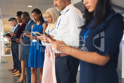 Business people using multimedia devices in business seminar