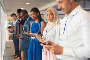 Business people using multimedia devices in business seminar