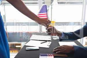 Business people holding an American flag at conference registration table