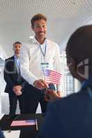 Businessman holding an American flag at conference registration table
