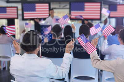 Business people waving an American flag in business seminar