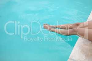 Woman sitting at the edge of swimming pool