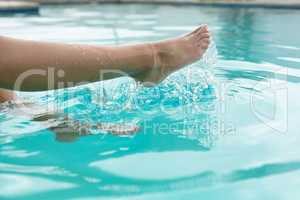 Woman splashing water in swimming pool