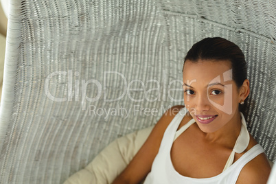 Beautiful woman at home in comfortable hanging chair