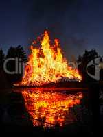 Flammen eines enormen Feuers nachts nahe am See