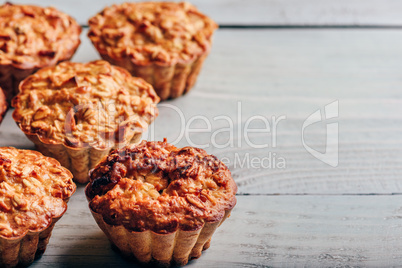 Cooked muffins on wooden background.