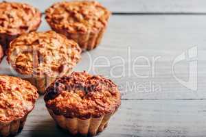 Cooked muffins on wooden background.