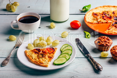 Frittata with with cup of coffee, grapes and muffins.