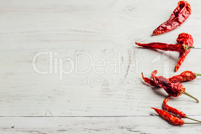 Dried chili peppers over wooden background