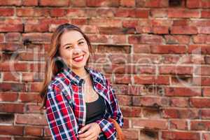 Portrait of young woman against brick wall